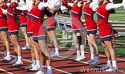High school cheerleaders cheering during football game Stock Photo