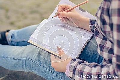 Close up photo of woman`s hands writing essay in her notepad Stock Photo