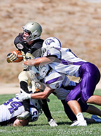 High School Football Player Being Tackled During a Game Editorial Stock Photo