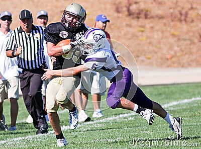 High School Football Player Being Tackled During a Game Editorial Stock Photo