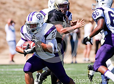 High School Football Player Running with the Ball During a Game Editorial Stock Photo