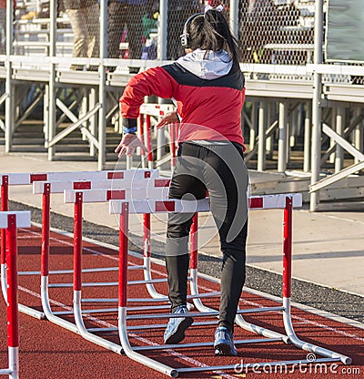 Female hurdle runner wearing headphones Editorial Stock Photo