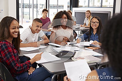 High school kids looking to teacher sitting at their desk Stock Photo