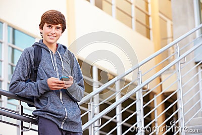 High School Student Standing Outside Building With Phone Stock Photo