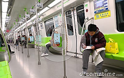 High school students who write homework on the subway Editorial Stock Photo