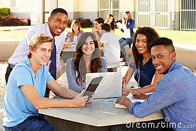 High School Students Working On Campus With Teacher Stock Photo