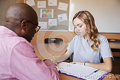 High School Tutor Giving Female Student One To One Tuition At Desk Stock Photo