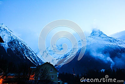 High snow-capped mountains in fog Stock Photo