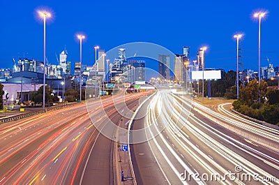 High speed traffic and light trails in highway at twilight Stock Photo