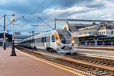 High speed train at the railway station at sunset Stock Photo