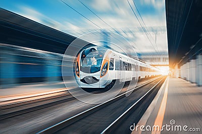 High speed train at the railway station at sunset Stock Photo