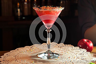 High stem glass with red alcohol drink and black straw on white napkin Stock Photo