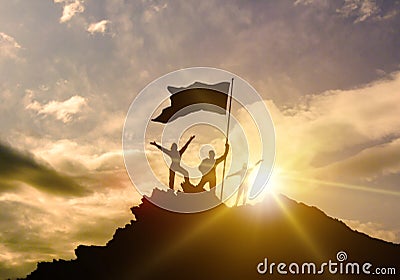 High success, family three silhouette, father of mother and child holding flag of victory on top of mountain, hands up. Stock Photo