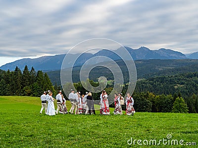 High Tatra mountains in Poland. View from Lapszanka near Zakopan. People in traditional outfit having wedding photoshoot in Editorial Stock Photo