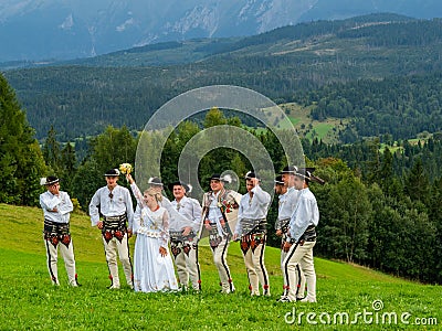 High Tatra mountains in Poland. View from Lapszanka near Zakopan. People in traditional outfit having wedding photoshoot in Editorial Stock Photo