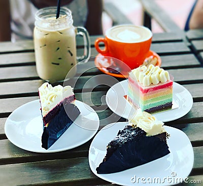 High tea time. Ice coffee, latte, rainbow cake , red velvet cheese cake & black forest cake Stock Photo