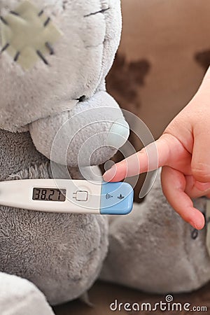 High temperature on an electronic thermometer. bear with a thermometer. baby temperature Stock Photo