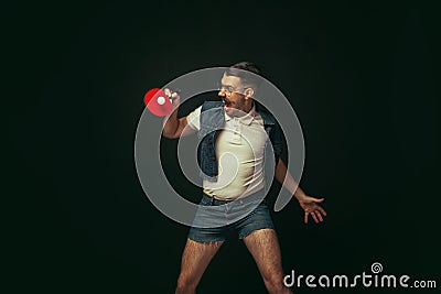 Young caucasian man playing tennis isolated on black studio background in retro style, action and motion concept Stock Photo