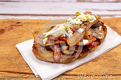 High view of a rustic bread brusquette with mayonnaise, bacon, mushrooms and vinaigrette, drizzled with EVOO or olive oil. Typical Stock Photo