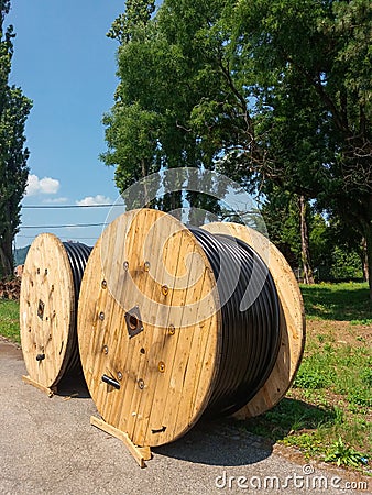 High voltage black electrical cable rolled on large cable reels Stock Photo