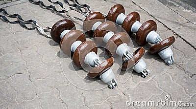 High voltage electricity cable connected with brown ceramic insulators Stock Photo