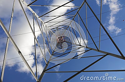 High Voltage Electricity Grid Pylon seen from below with blue sky Stock Photo