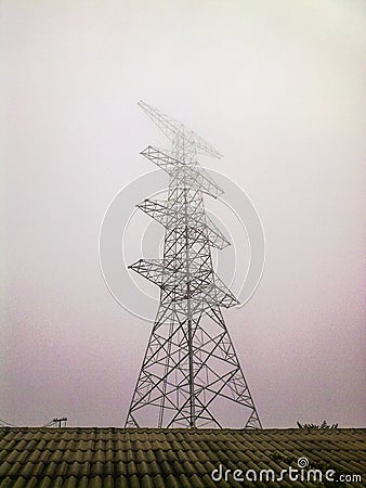 High voltage electricity pylon in the morning mist. Stock Photo