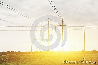 High voltage lines and power pylons in a flat and green agricultural landscape on a sunny day Stock Photo