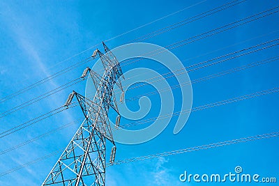 High voltage pole with blue sky background, Electric transmission line system for large industrial plants. Stock Photo