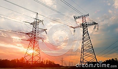 High-voltage power lines at sunset or sunrise. High voltage electric transmission tower Stock Photo