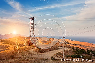 High voltage tower in mountains at sunset. Electricity pylon system Stock Photo