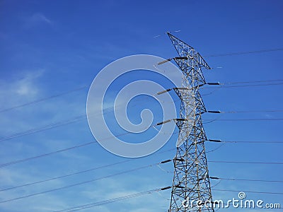 High voltage tower power line against blue sky. Stock Photo