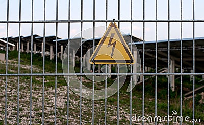 High voltage warning sign at fence of solar field Stock Photo