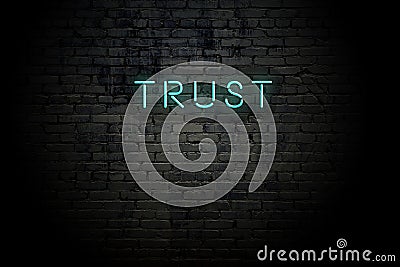 Highlighted brick wall with neon inscription trust Stock Photo