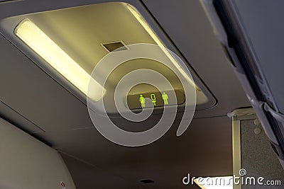 Passenger plane interior details. Highlighted lavatory sign Stock Photo