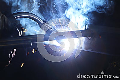 A highly skilled welder welds a metal structure at an assembly plant Stock Photo