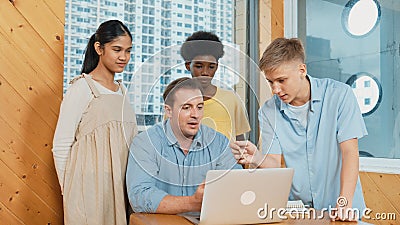 Highschool boy presenting project while teacher looking at laptop. Edification. Stock Photo