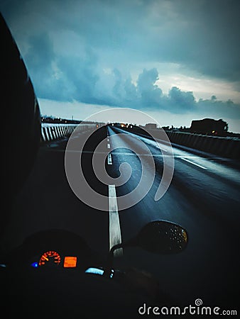 Highway bike ride at evening time during monsoon season with rainy and cloudy weather Stock Photo