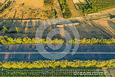 Highway from a bird's eye view. As the sun goes down, the sun's rays create beautiful long shadows on the ground. Stock Photo