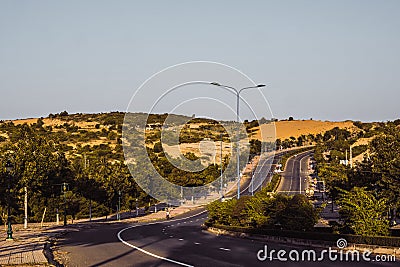 Highway curve road overpass nature landscape background dark tone mist day time street tall lanterns trees bushes Stock Photo