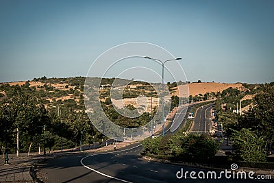 Highway curve road overpass nature landscape background dark tone mist day time street tall lanterns trees bushes Stock Photo