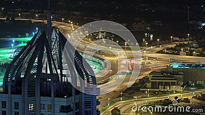 Highway intersection at night with tower from rooftop timelapse. Dubai, UAE Stock Photo