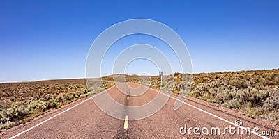 Long highway in the american countryside, clear blue sky Stock Photo