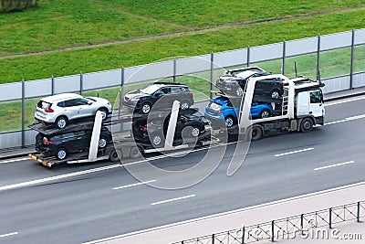 Highway transportation of new cars on a trailer with a truck for delivery to dealers Stock Photo