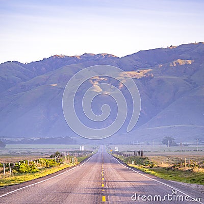 Highway with view of an immense mountain in CA Stock Photo