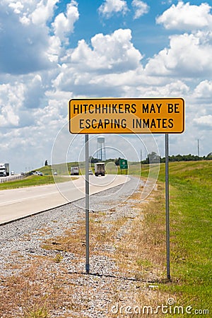 Highway warning sign about hitchhikers that might escaping inmates Stock Photo