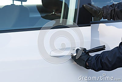 Hijacker opens a car door with a screwdriver to steal Stock Photo