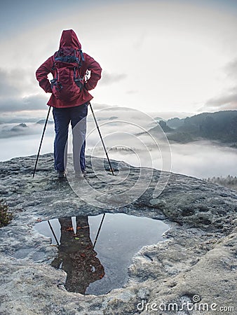 Hike with backpack and trekking sticks at edge. Woman visit Stock Photo