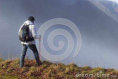 Hiker above the clouds Stock Photo