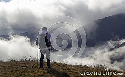 Hiker above the clouds Stock Photo